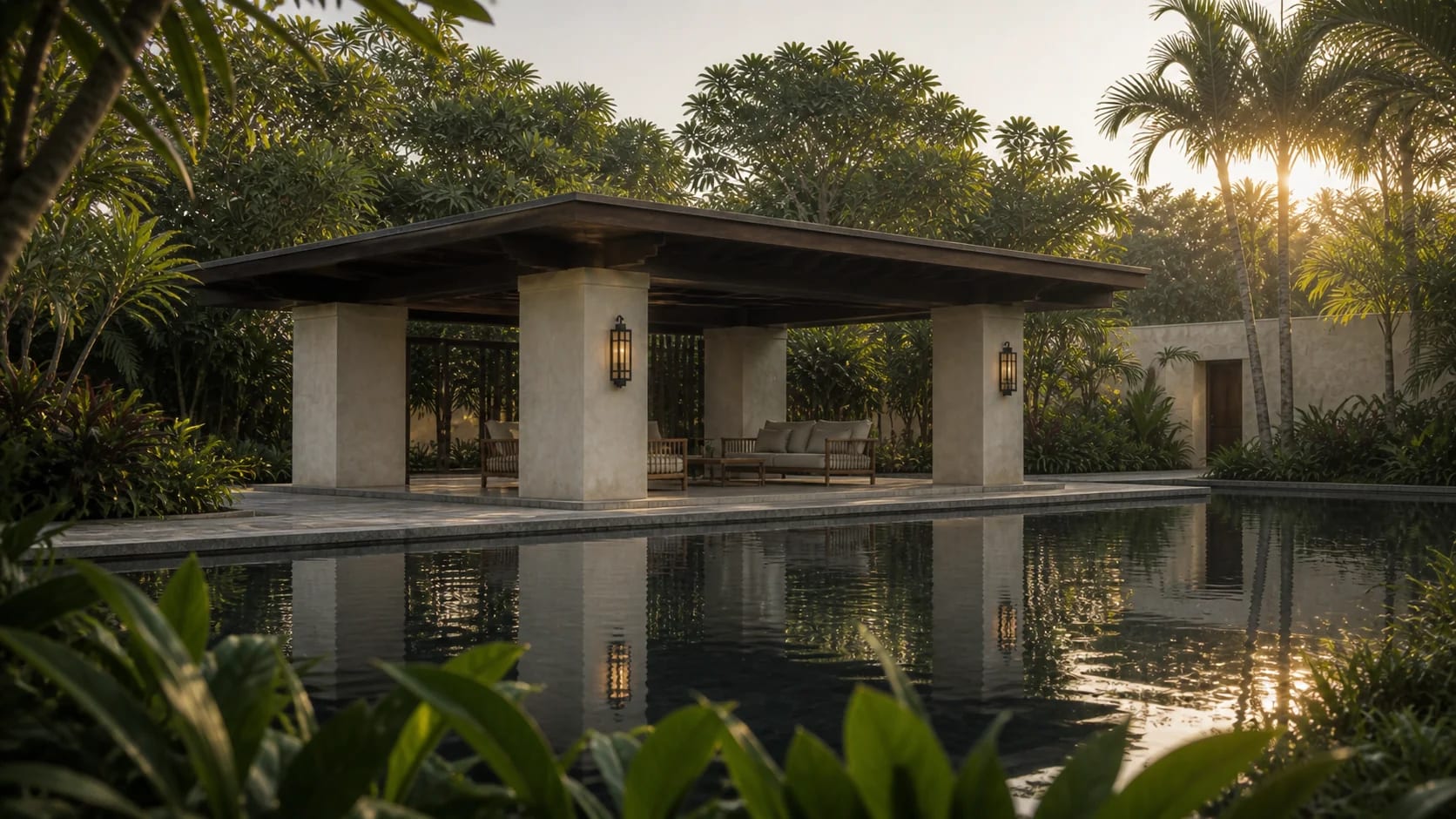 A stone-and-plaster pavilion mirrored in a still reflecting pool at golden hour, among palms.